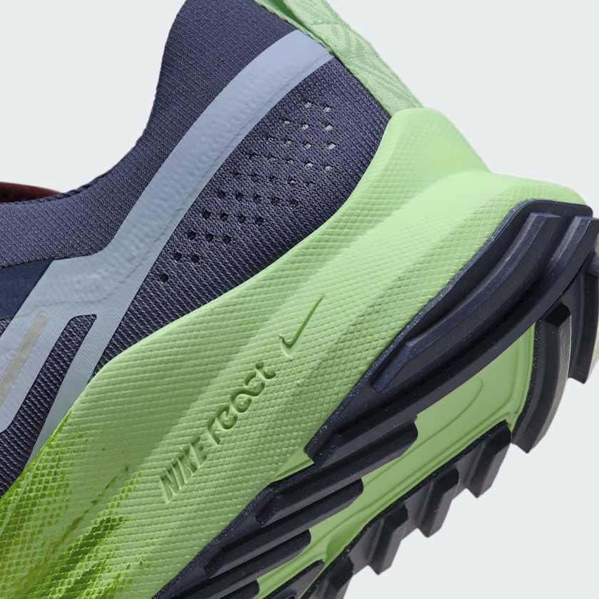 Detailed zoom on the outsole and midsole of the Nike React Pegasus Trail 4 Men's blue running shoes, highlighting the responsive React foam cushioning and rugged rubber outsole.