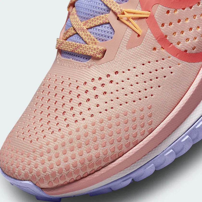 Close-up zoom on the front of the Nike Pegasus Trail 4 Women's pink running shoes, showing the breathable mesh texture, lacing system, and protective toe overlay.
