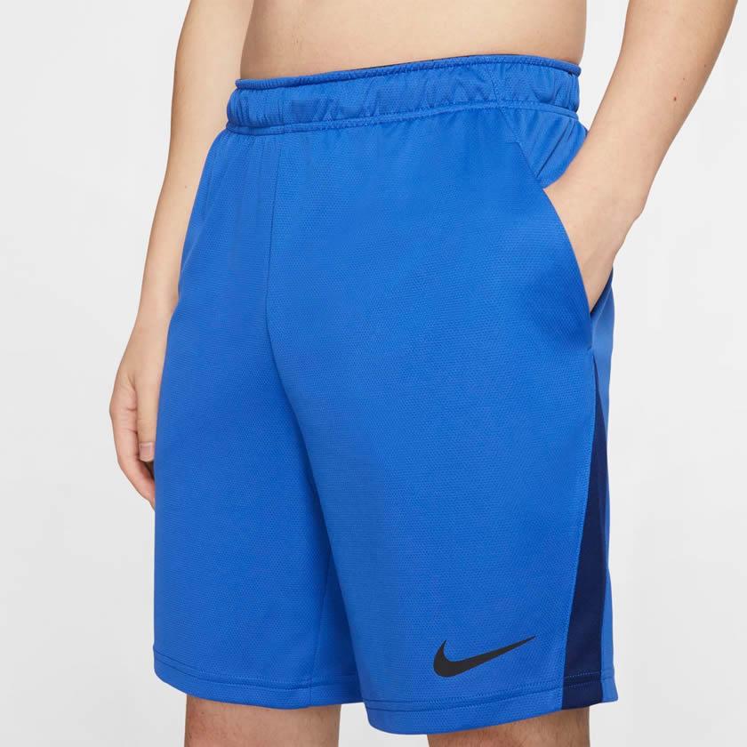 Close-up zoom on the fabric of the Nike Men's Dri-FIT 8" running shorts in obsidian, showing the lightweight, moisture-wicking texture and the embroidered white Nike Swoosh.
