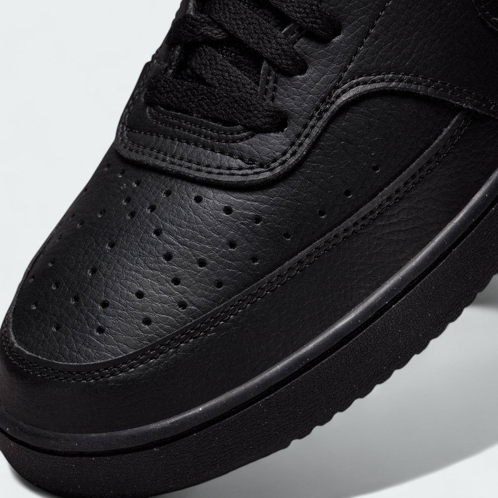 Close-up zoom on the front of the Nike Court Vision Mid Next Nature Men's black shoes, showing the perforated toe box, lacing system, and texture of the upper materials.