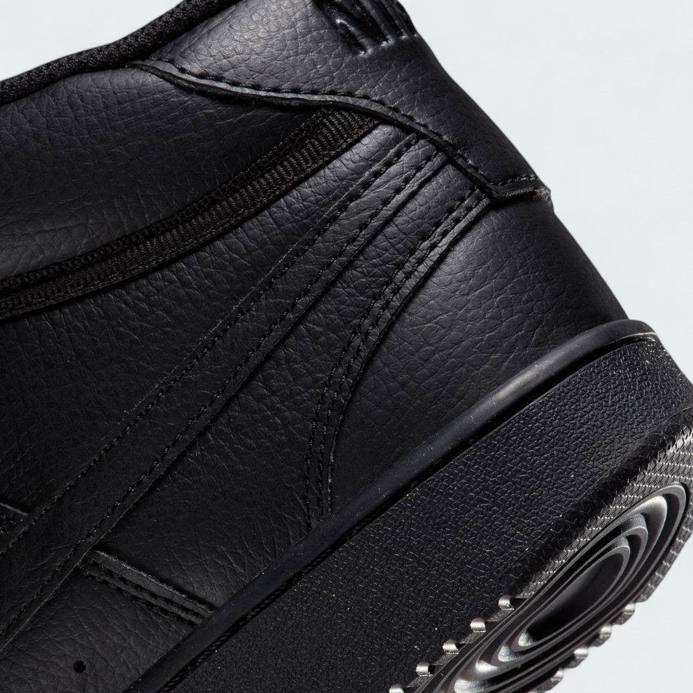 Detailed zoom on the midsole of the Nike Court Vision Mid Next Nature Men's black shoes, highlighting the classic cupsole construction and any subtle 'Next Nature' branding.