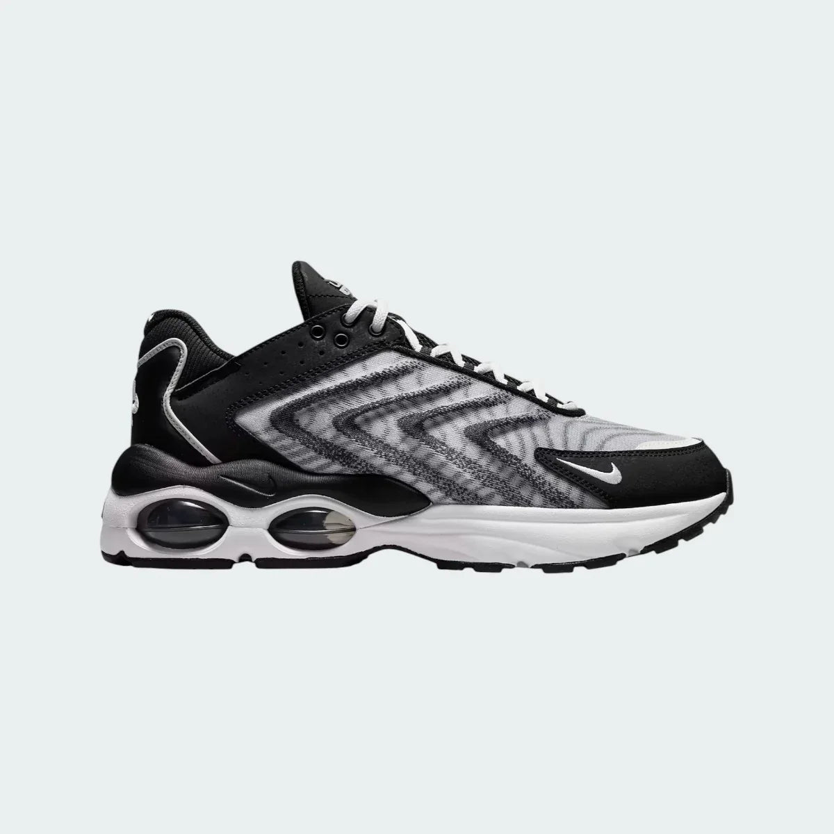 Nike Air Max TW trainers in black and white, side profile showing the layered, angular upper design and the visible Air Max unit with multiple windows in the heel.