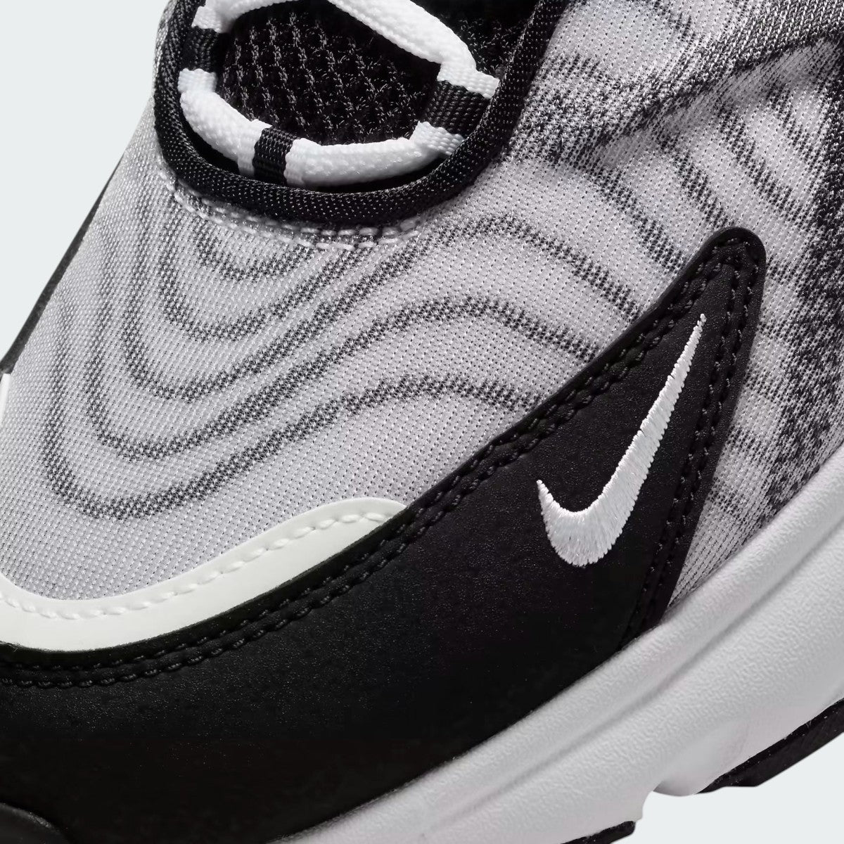 Close-up zoom on the side of the Nike Air Max TW trainers, detailing the haptic texture, angular synthetic overlays, and the visible Air unit.