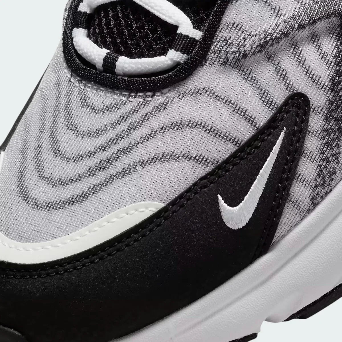 Close-up zoom on the side of the Nike Air Max TW trainers, detailing the haptic texture, angular synthetic overlays, and the visible Air unit.