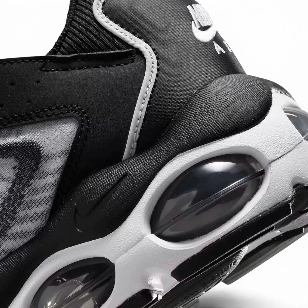 Close-up zoom on the side of the Nike Air Max TW trainers, detailing the haptic texture, angular synthetic overlays, and the visible Air unit.