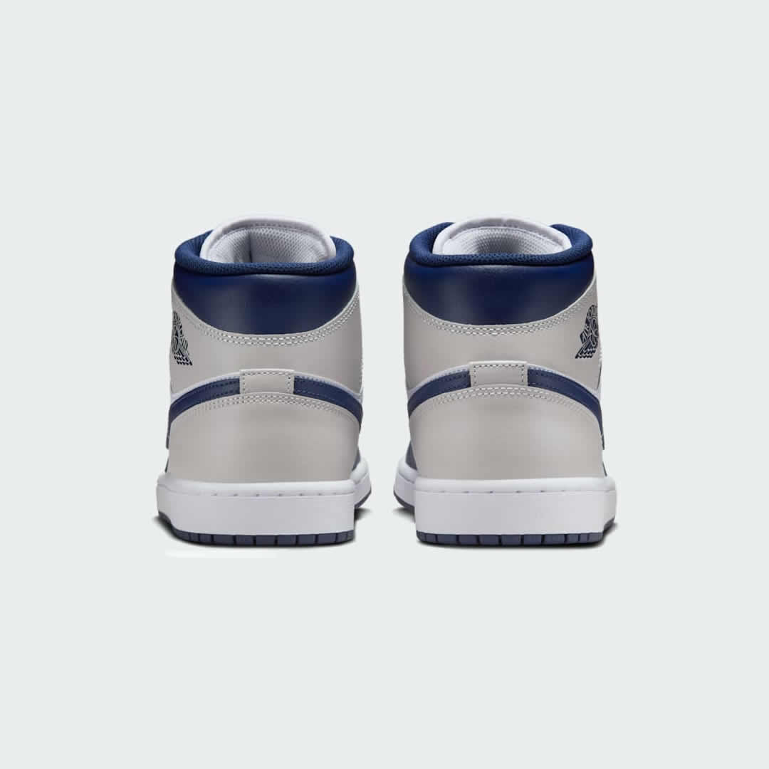 Rear view of the Air Jordan 1 Mid Men's trainers, focusing on the Wings logo on the ankle collar and contrasting heel panels.