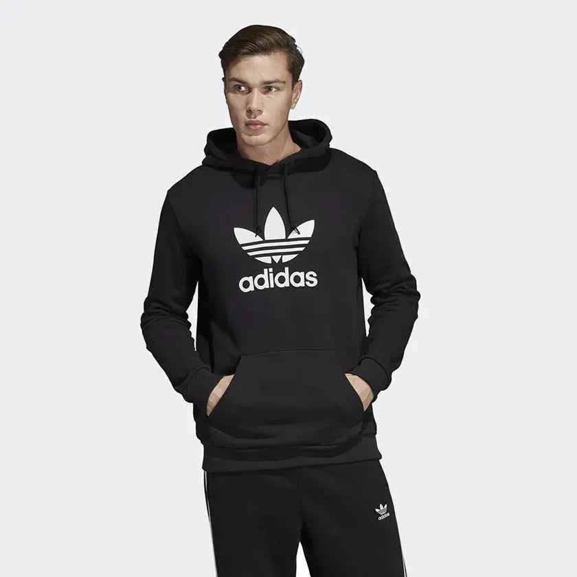Adidas Trefoil Hoodie Men's in black, model worn front view showing large white Trefoil logo on the chest and a kangaroo pocket. Main image