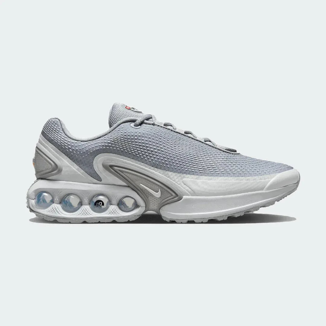 Nike Air Max DN Men's running shoes in grey, side profile showing visible Dynamic Air unit in the heel, textured upper, and sleek silhouette. Main image