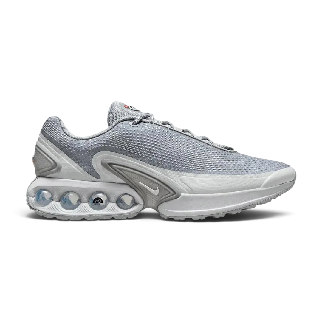 Nike Air Max DN Men's running shoes in grey, side profile showing visible Dynamic Air unit in the heel, textured upper, and sleek silhouette.