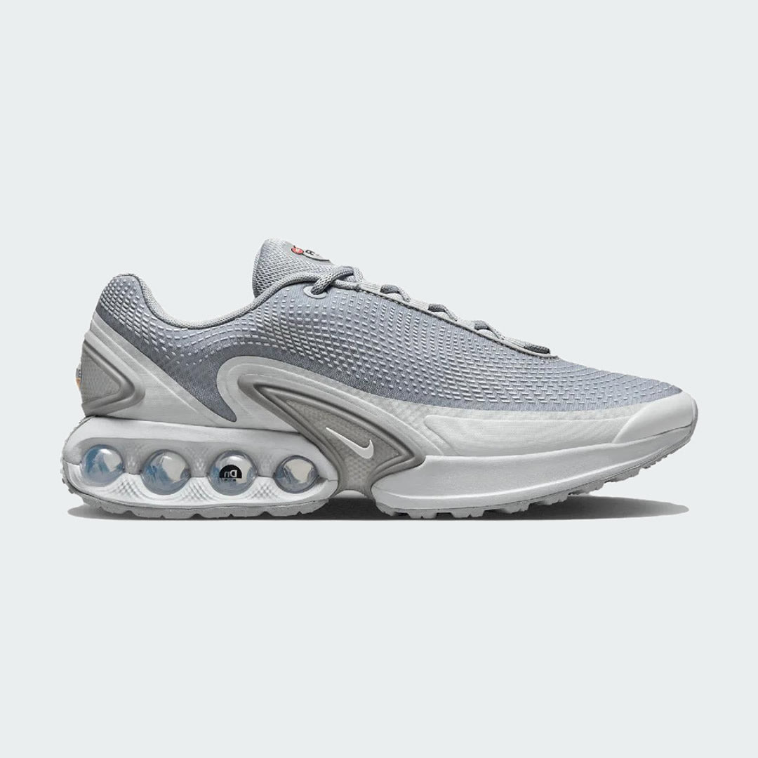 Nike Air Max DN Men's running shoes in grey, side profile showing visible Dynamic Air unit in the heel, textured upper, and sleek silhouette.