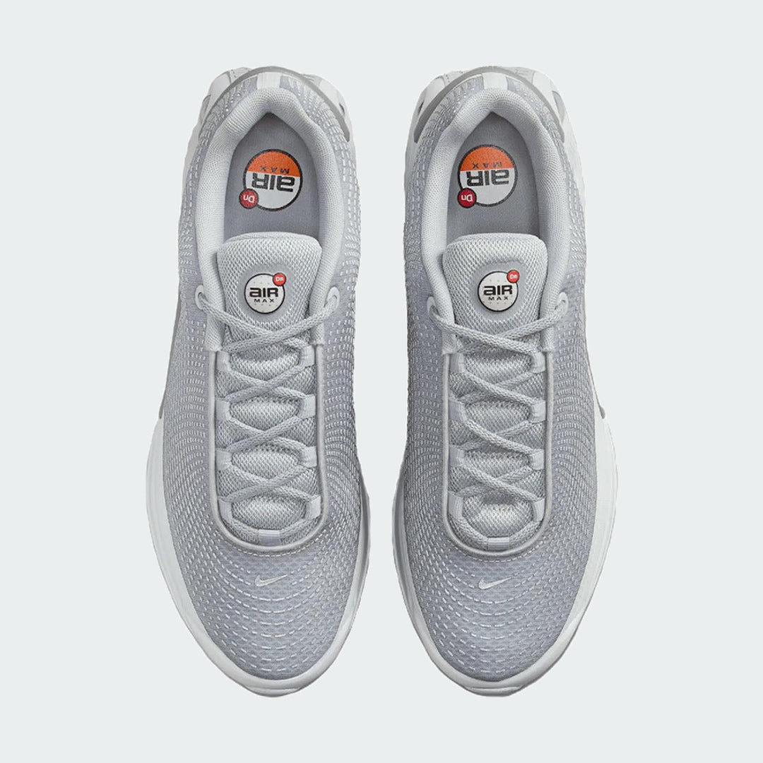 Top-down view of a pair of Nike Air Max DN Men's running shoes in grey, highlighting their futuristic design and lace-up closure.