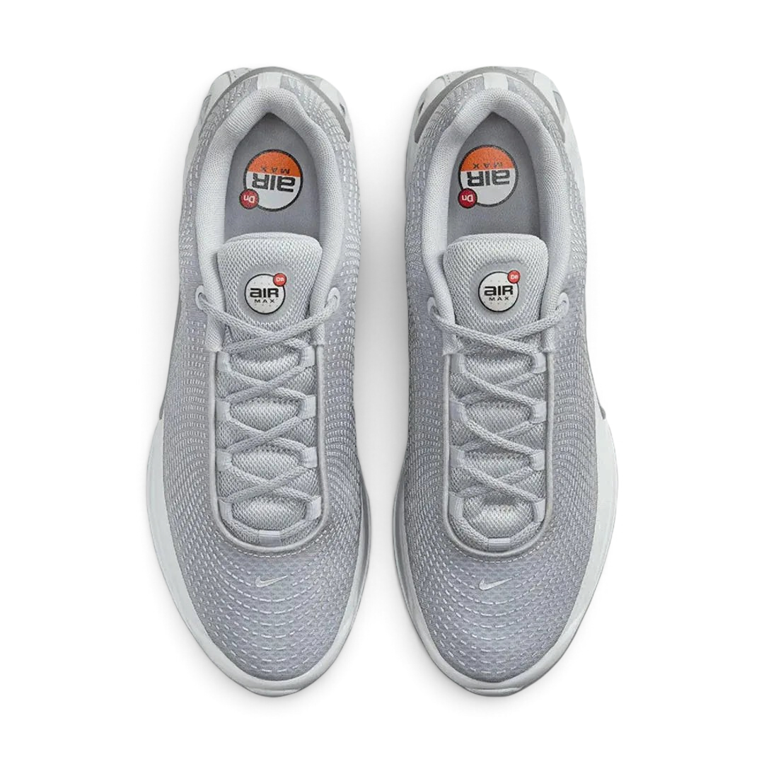 Top-down view of a pair of Nike Air Max DN Men's running shoes in grey, highlighting their futuristic design and lace-up closure.
