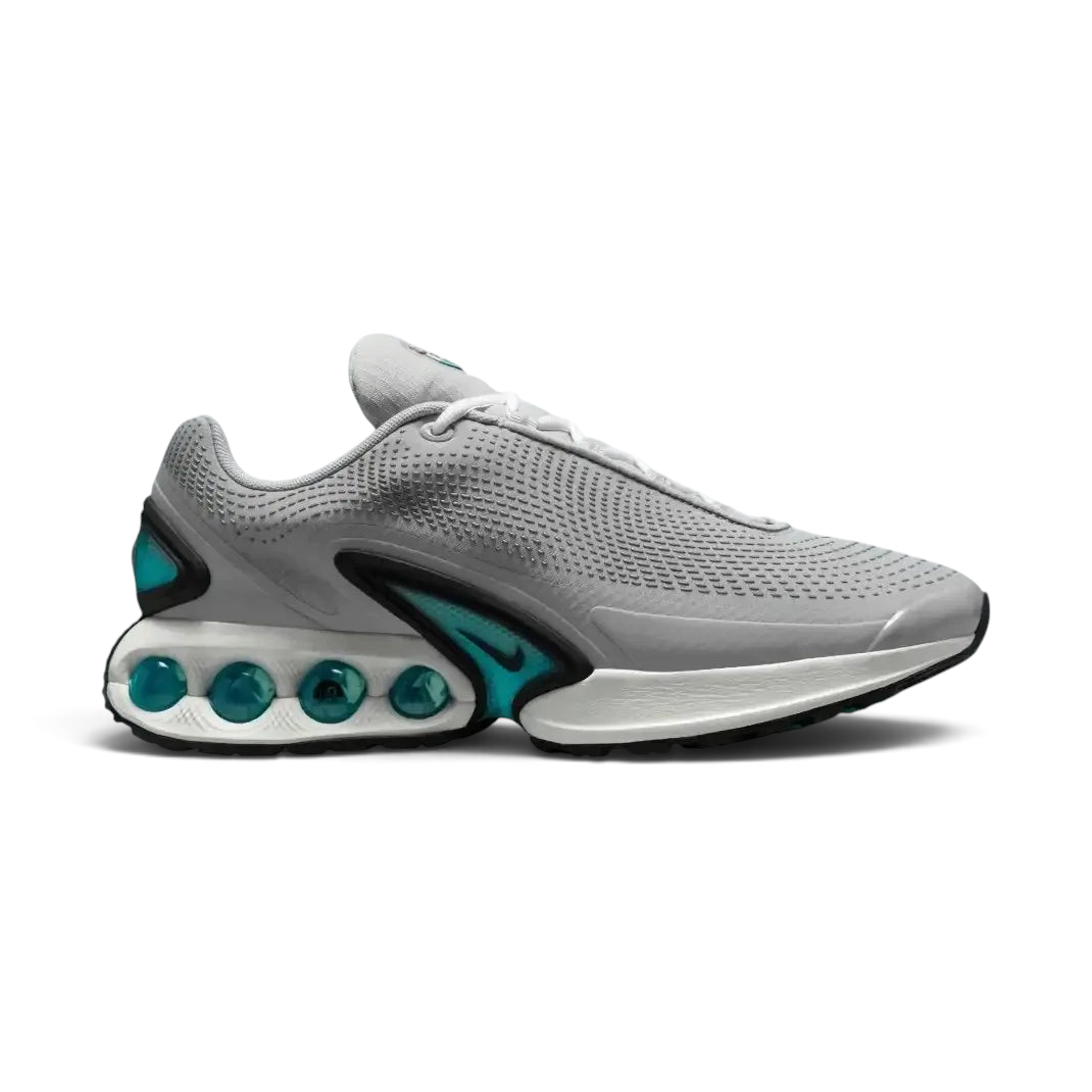 Nike Air Max DN Men's running shoes in light smoke grey and black, side profile showing visible Dynamic Air unit in the heel, textured upper, and sleek silhouette. Main image