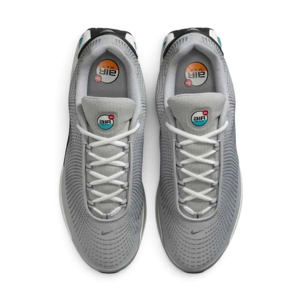 Top-down view of a pair of Nike Air Max DN Men's running shoes in grey, highlighting their futuristic design and lace-up closure.