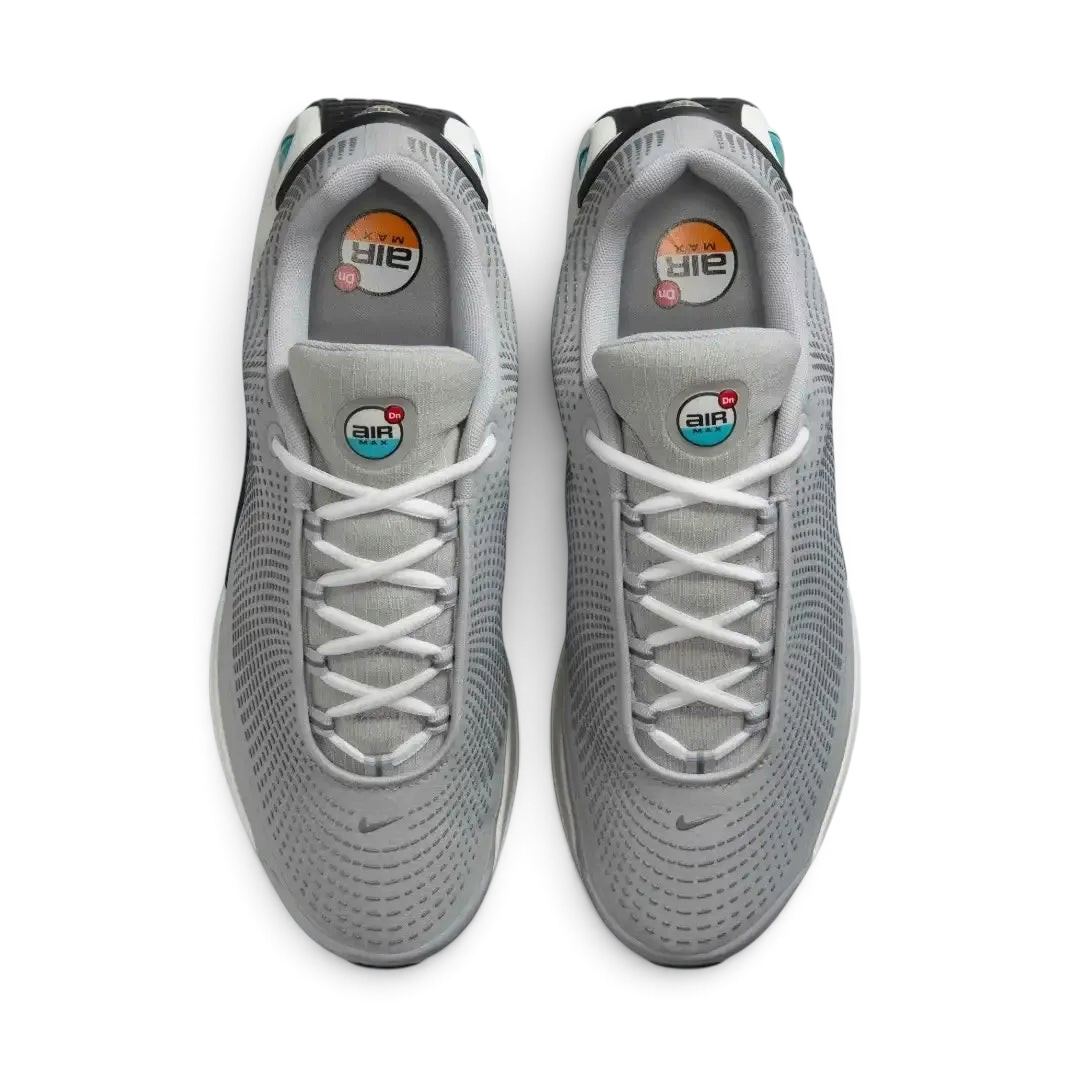 Top-down view of a pair of Nike Air Max DN Men's running shoes in grey, highlighting their futuristic design and lace-up closure.