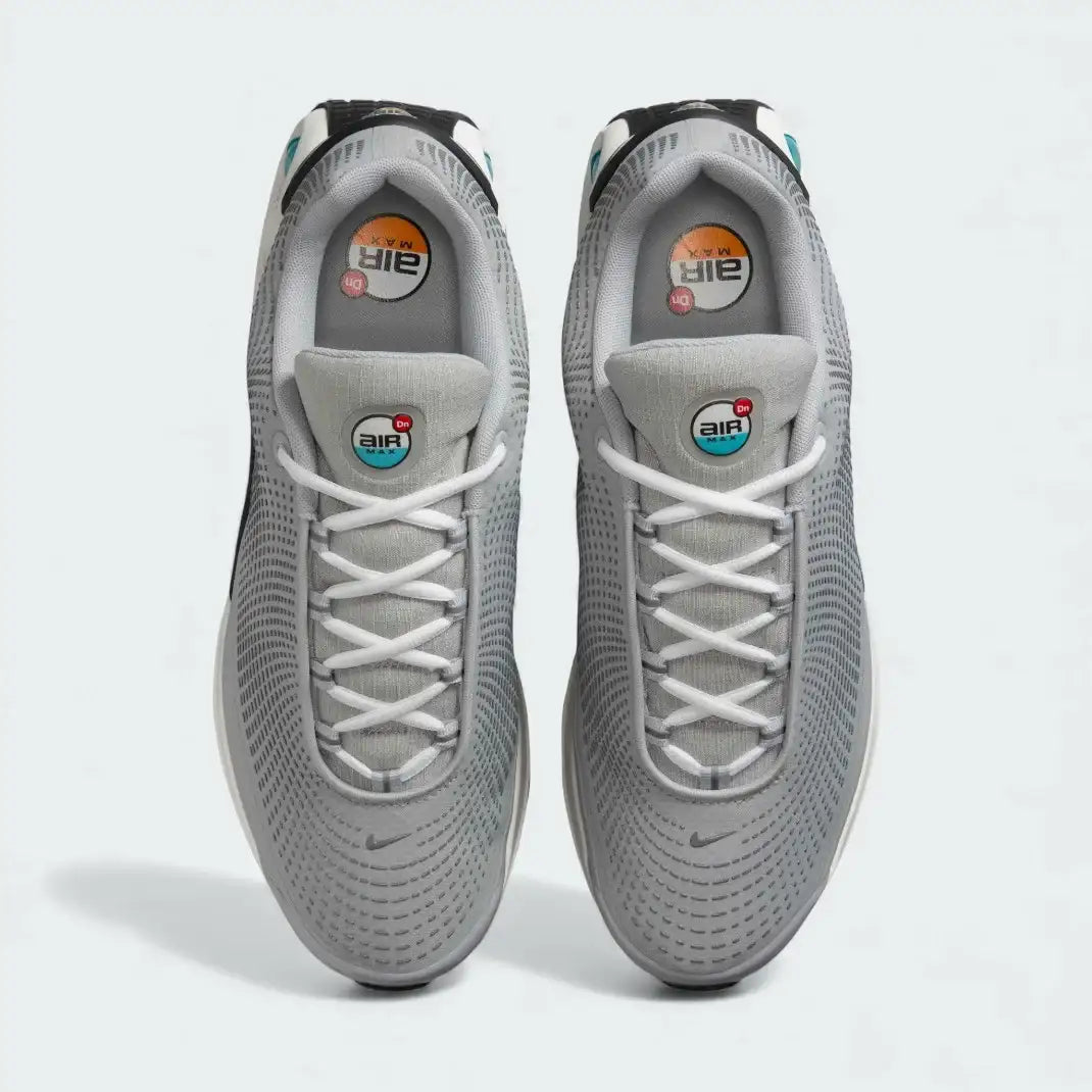 Top-down view of a pair of Nike Air Max DN Men's running shoes in grey, highlighting their futuristic design and lace-up closure.
