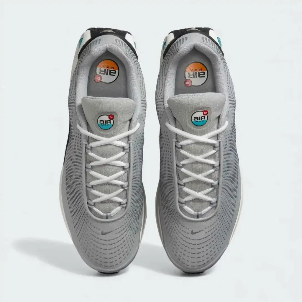 Top-down view of a pair of Nike Air Max DN Men's running shoes in grey, highlighting their futuristic design and lace-up closure.