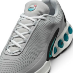 Close-up zoom on the front of the Nike Air Max DN Men's grey running shoes, showing the mesh upper texture, haptic print details, and lacing system.