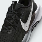 Close-up view of the lateral forefoot and lace tracking, detailing the open-hole mesh ventilation, Flywire lace loops, printed "NIKE TRAIL" eyelet tab, and the micro-textured white Swoosh over the grid-pattern midfoot overlay.
