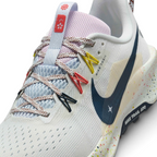 Details the micro-precision of the open-cell forefoot mesh upper, showing the flecked laces, floral tongue badge, and vibrant yellow and coral Flywire cables.