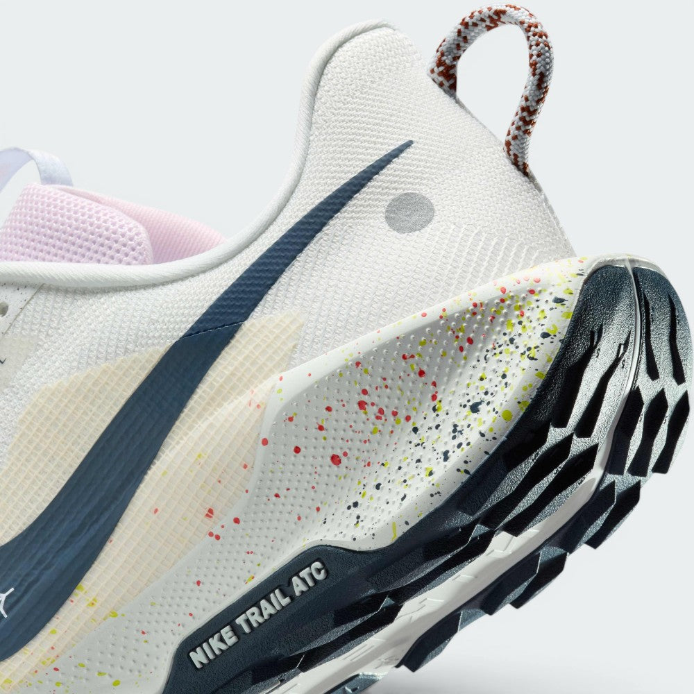 Highlights the "unreal" clean finish where the paint-splattered ReactX foam midsole meets the dark navy ATC rubber tread, showing the debossed "NIKE TRAIL ATC" outsole frame.