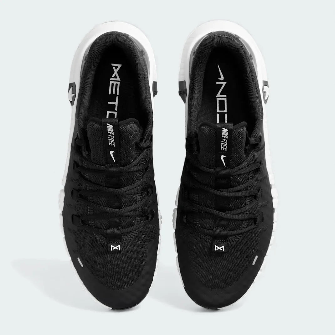 Top-down view of a pair of Nike Free Metcon 5 Men's training shoes in black, highlighting their athletic silhouette and lace-up closure.