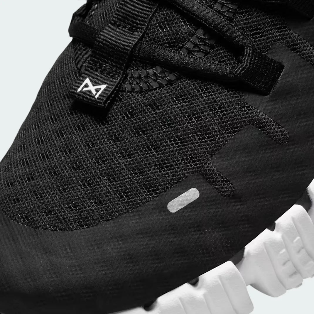 Close-up zoom on the front of the Nike Free Metcon 5 Men's black training shoes, showing the breathable mesh upper texture, lacing system, and flexible toe area.