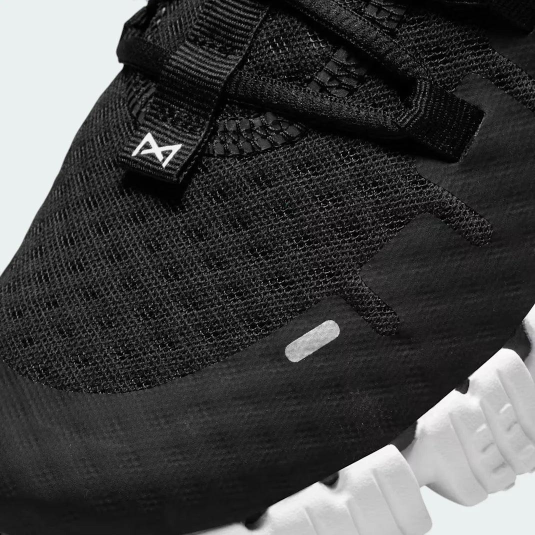Close-up zoom on the front of the Nike Free Metcon 5 Men's black training shoes, showing the breathable mesh upper texture, lacing system, and flexible toe area.