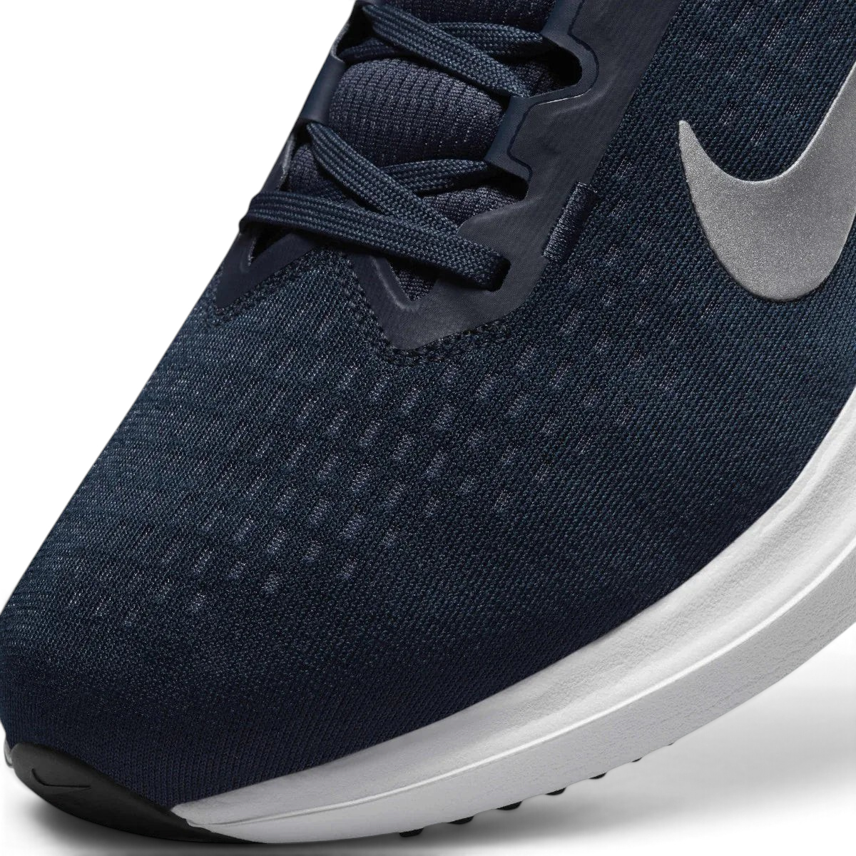 Close-up zoom on the front of the Nike Air Winflo 10 Men's navy running shoes, showing the mesh upper texture, lacing system, and synthetic overlays.