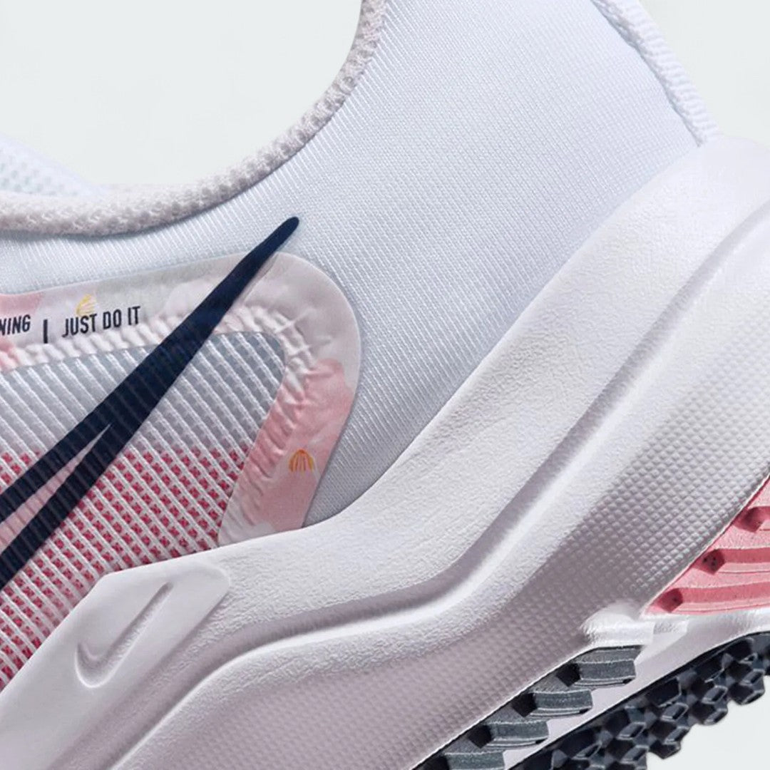 Detailed zoom on the outsole and midsole of the Nike Downshifter 12 Premium Women's white training shoes, highlighting the soft foam cushioning and durable rubber outsole.