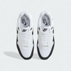 Top-down view of a pair of Nike Air Max 1 Women's running trainers in white, highlighting their iconic silhouette and lace-up closure.