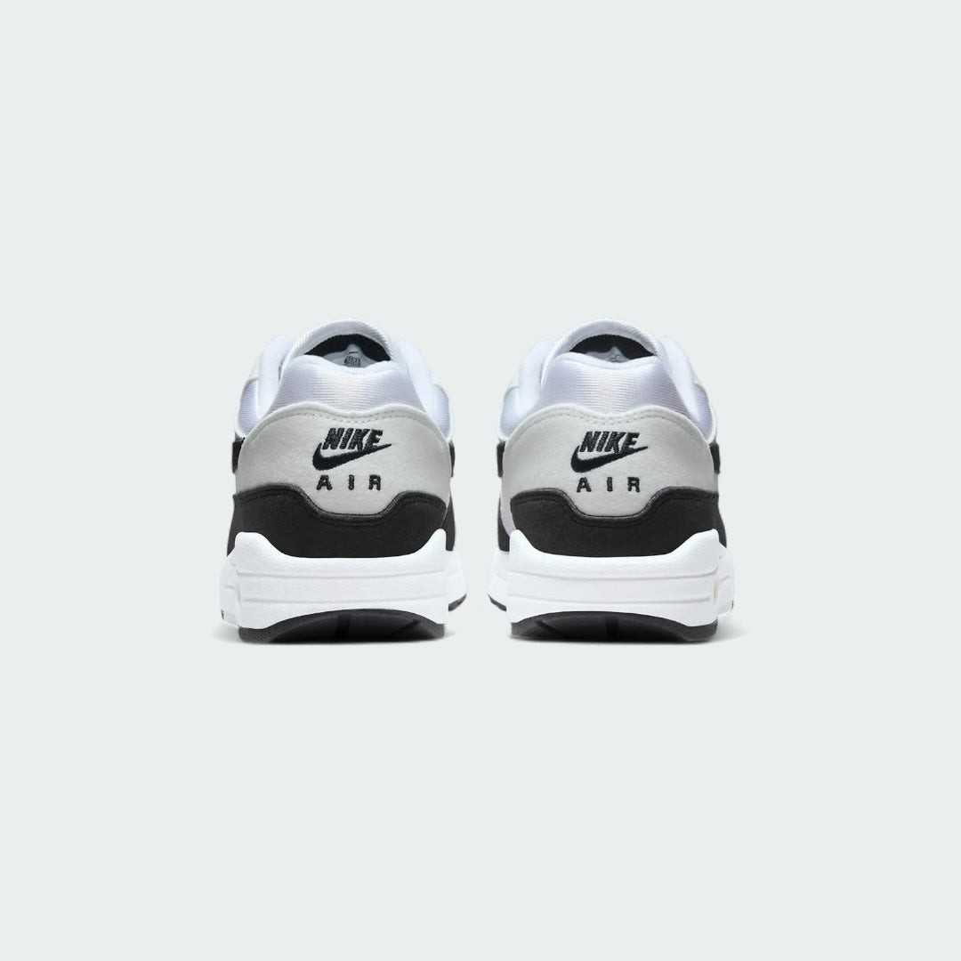 Rear view of the Nike Air Max 1 Women's white trainers, focusing on the prominent Nike Air branding on the heel and padded collar.