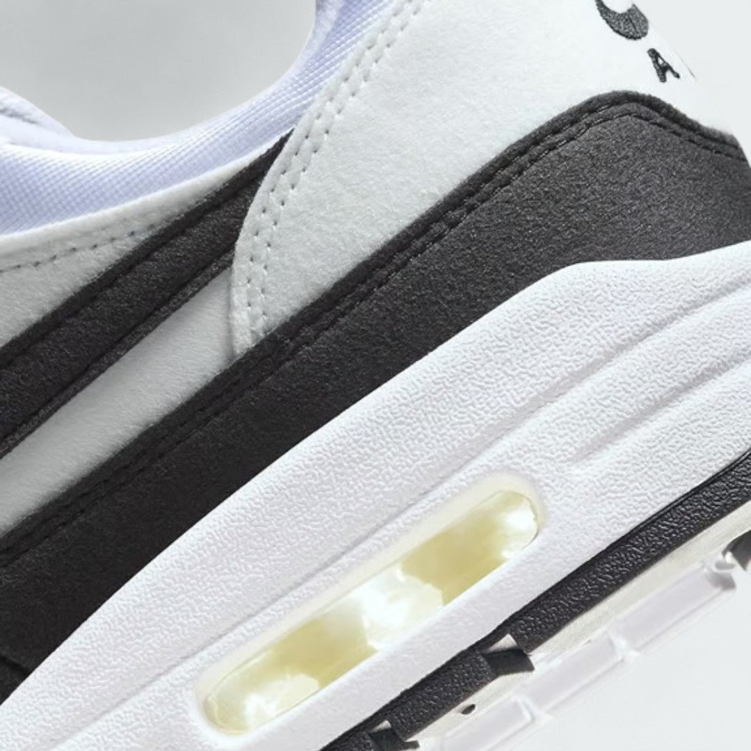 Detailed zoom on the outsole and midsole of the Nike Air Max 1 Women's white trainers, highlighting the cushioned foam and visible Max Air unit.