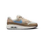Nike Air Max 1 Juniors' trainers in light bone brown with a psychic blue Swoosh, side profile showing visible Max Air unit in the heel and a layered leather upper.