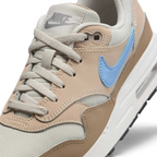 Close-up zoom on the front of the Nike Air Max 1 Juniors' trainers, showing the mesh toe box, lacing system, and textured leather overlays.