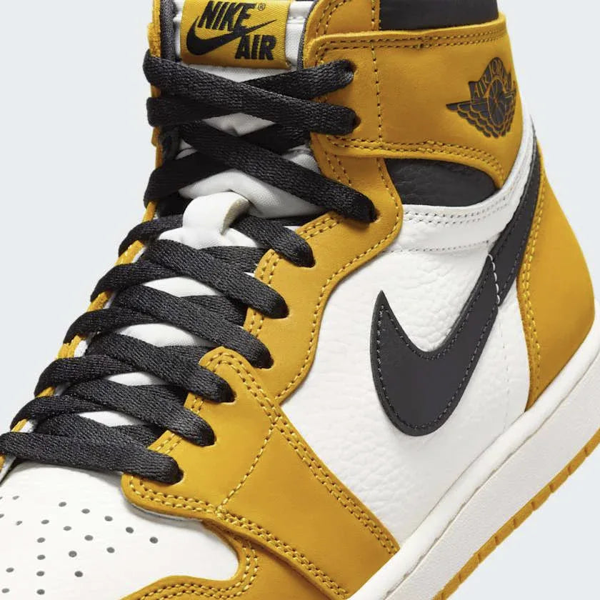 Close-up zoom on the front of the Air Jordan 1 Retro High OG Men's yellow trainers, showing the perforated toe box, lacing system, and textured leather upper.
