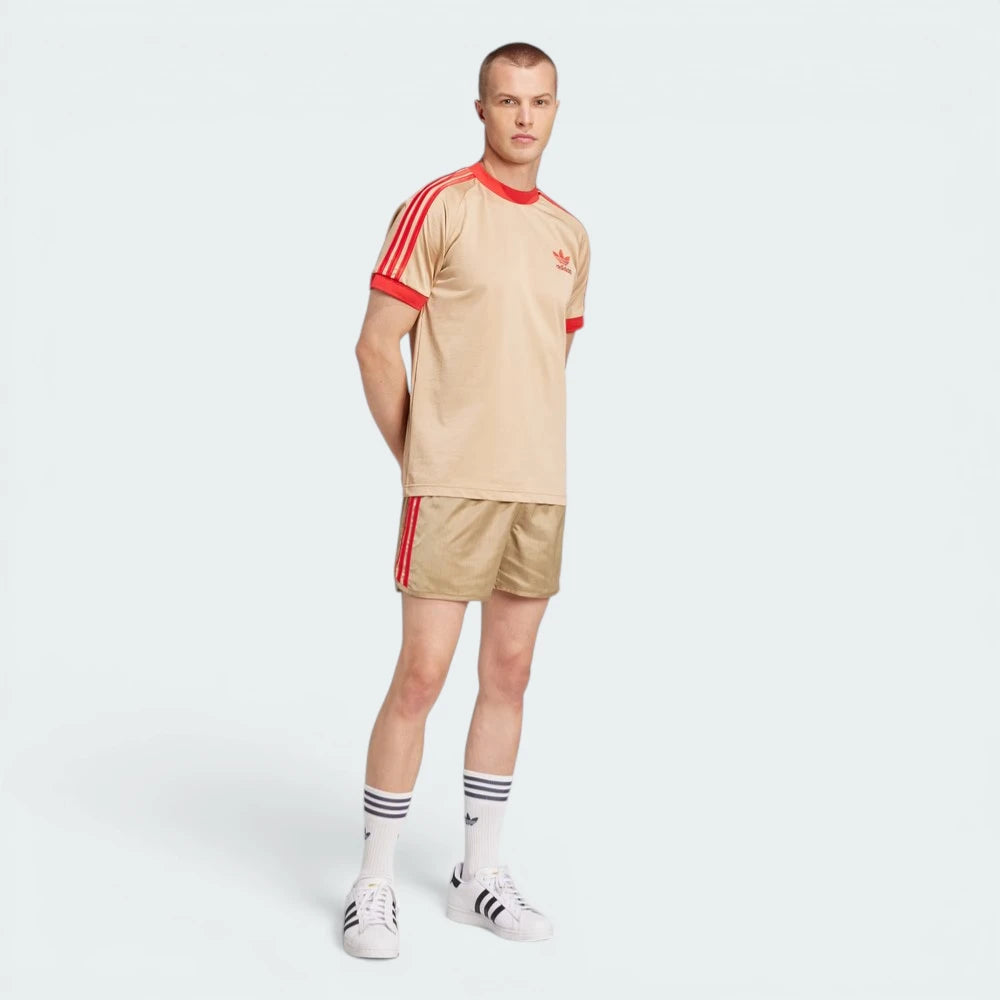 Angle view showing the front of the tee, emphasizing the premium embroidered Trefoil logo on the chest.