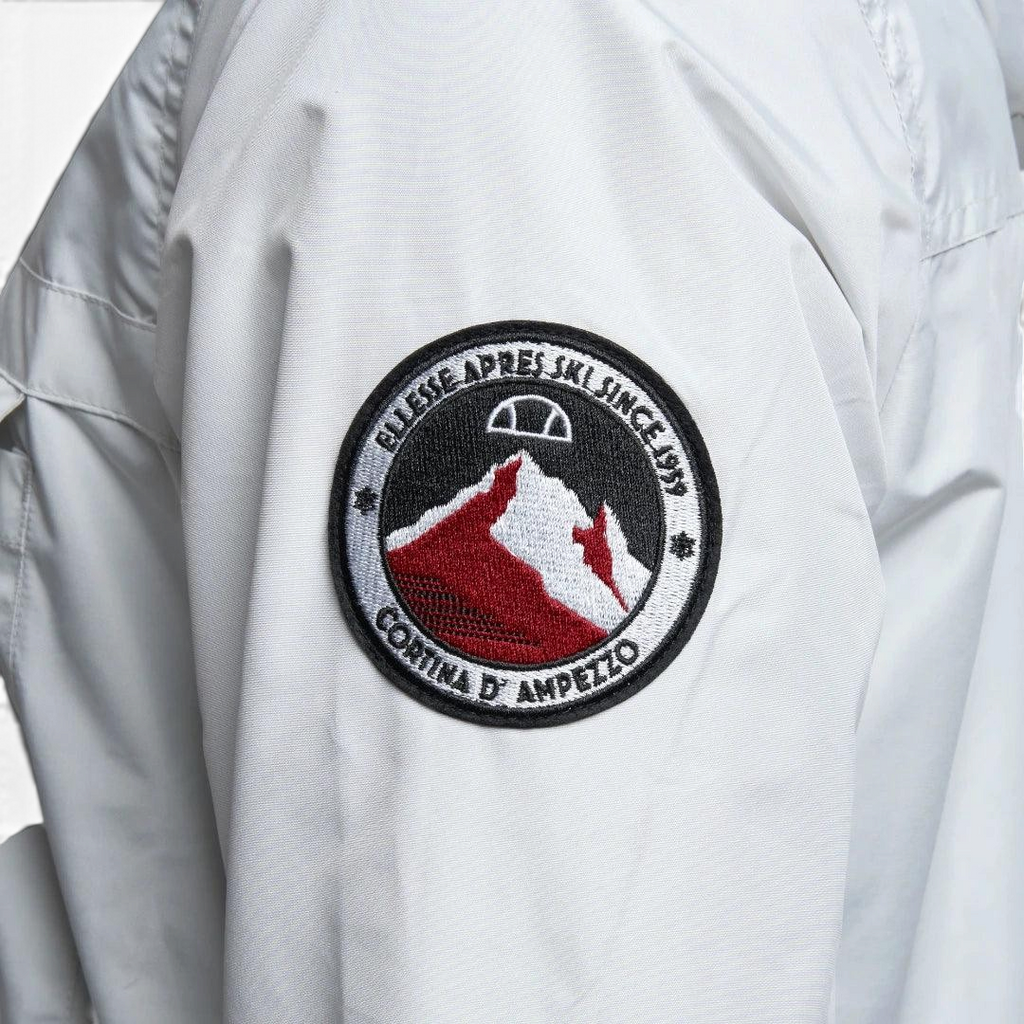 Close-up zoom on the fabric of the Ellesse Mont 2 Overhead Anorak Jacket, showing the textured marl finish and the embroidered or printed Ellesse logo.
