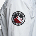 Close-up zoom on the fabric of the Ellesse Mont 2 Overhead Anorak Jacket, showing the textured marl finish and the embroidered or printed Ellesse logo.