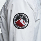 Close-up zoom on the fabric of the Ellesse Mont 2 Overhead Anorak Jacket, showing the textured marl finish and the embroidered or printed Ellesse logo.