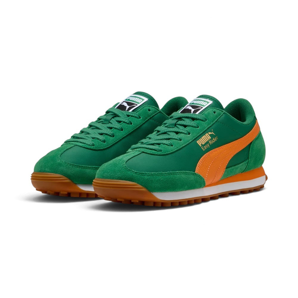 Forward three-quarter angle showcasing both shoes side by side, highlighting the retro slim-profile 1970s running silhouette, matching green laces, plush suede T-toe mudguards, and low-slung athletic stance.