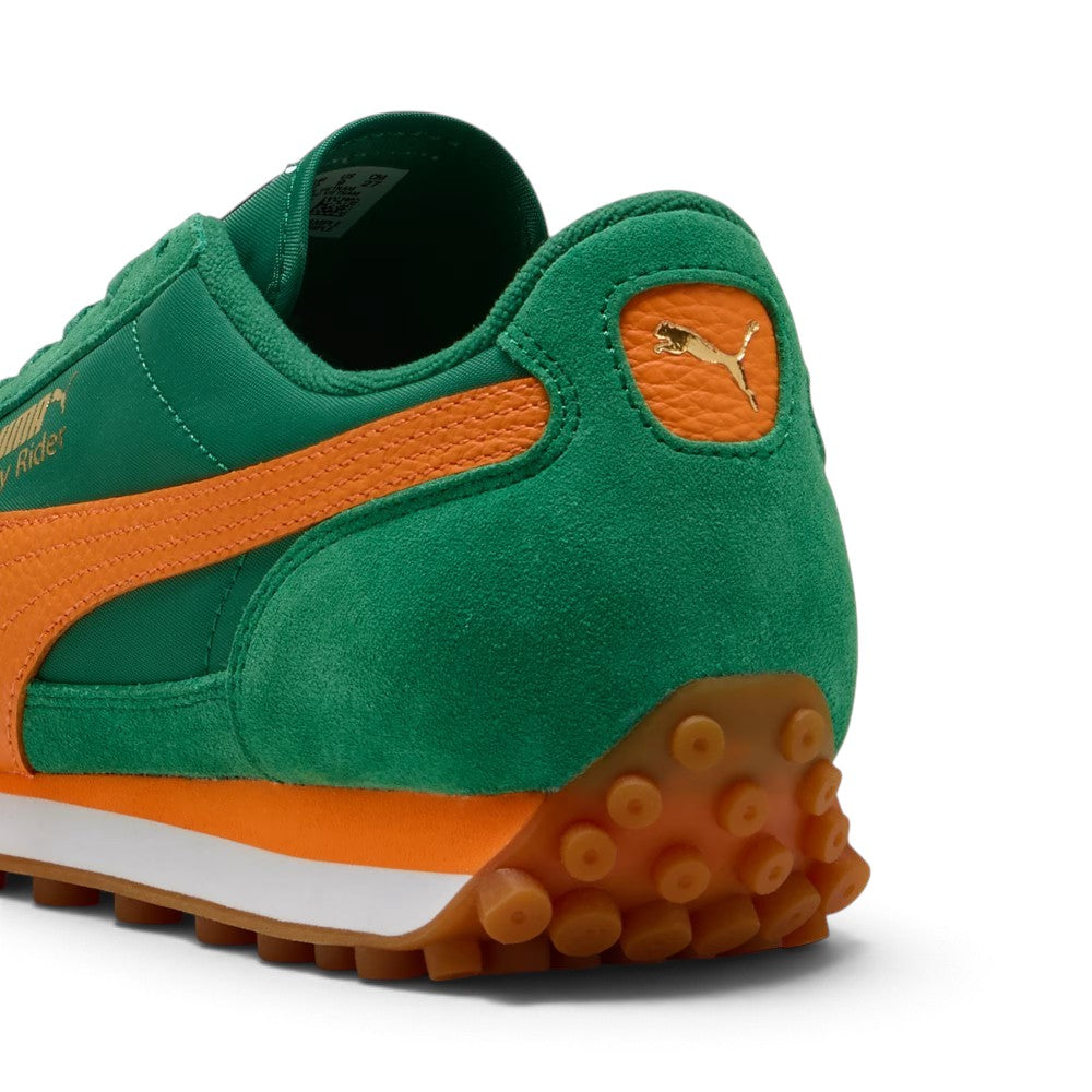 Close-up rear angle focusing on the suede heel counter, Rickie Orange leather moustache tab stamped with a gilded metallic PUMA Cat logo, and the studded gum rubber outsole extending upwards to protect the Achilles.