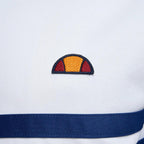 Close-up zoom on the fabric of the Ellesse Rimini Track Jacket in white, showing the smooth tricot texture and the embroidered Ellesse logo on the chest.
