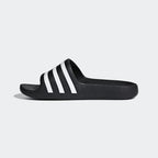 Black slide sandal with white stripes on a white background