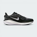 A Nike running shoe in black and white, featuring a textured black mesh upper, a white Nike Swoosh, and a thick white and black midsole, shown from a side profile on a light gray background.