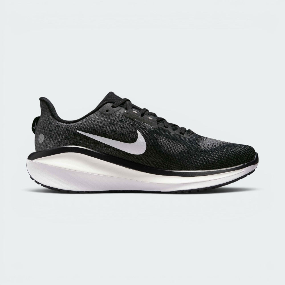 A Nike running shoe in black and white, featuring a textured black mesh upper, a white Nike Swoosh, and a thick white and black midsole, shown from a side profile on a light gray background.