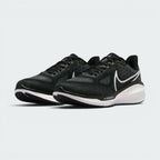 Emphasising the maximalist, forward-leaning athletic stance of the trainers and the professional harmony of the deep black uppers sitting cleanly above the white and dark charcoal sole tooling components.