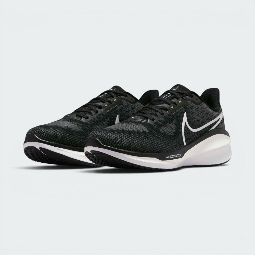 Emphasising the maximalist, forward-leaning athletic stance of the trainers and the professional harmony of the deep black uppers sitting cleanly above the white and dark charcoal sole tooling components.