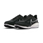 Emphasising the maximalist, forward-leaning athletic stance of the trainers and the professional harmony of the deep black uppers sitting cleanly above the white and dark charcoal sole tooling components.