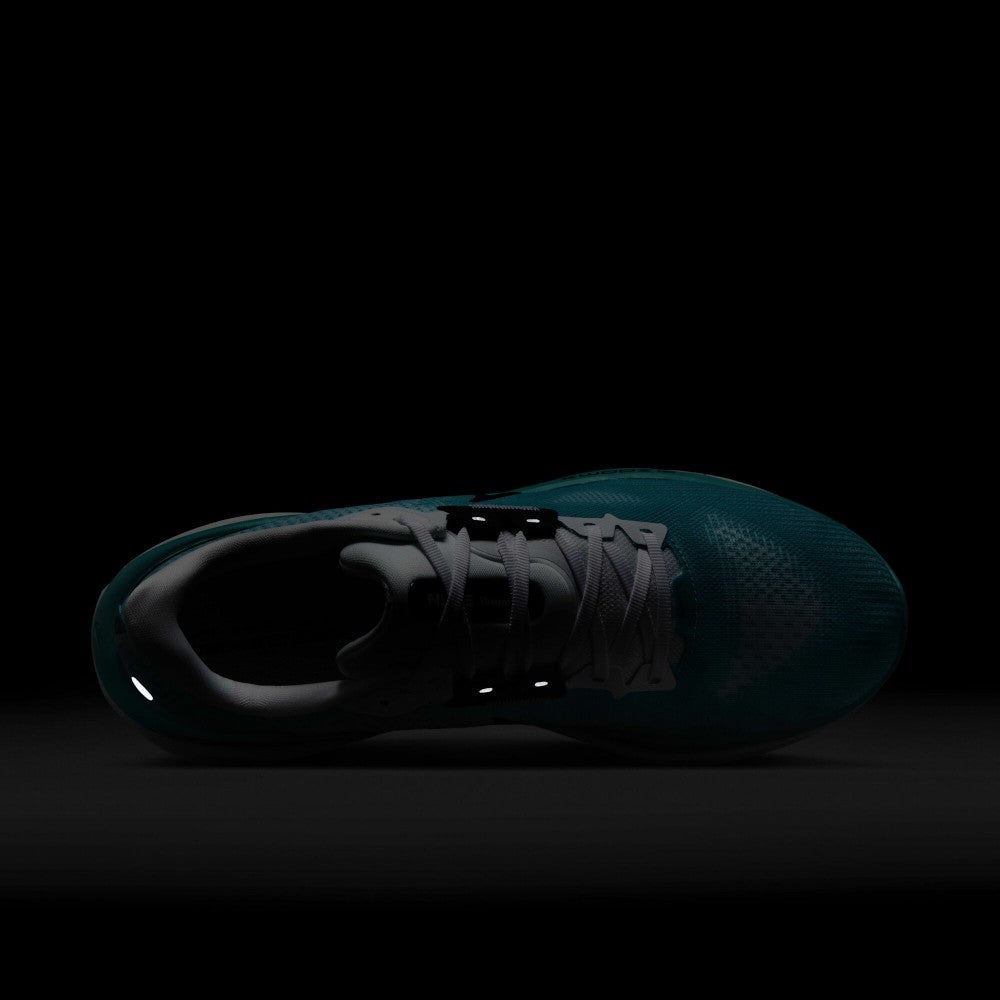 Demonstrates low-light safety visibility, showcasing the illuminated reflective accents on the midfoot eyestay anchors and heel counter against a darkened background.